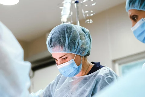 image of doctors in scrubs standing over a patient on an operating table